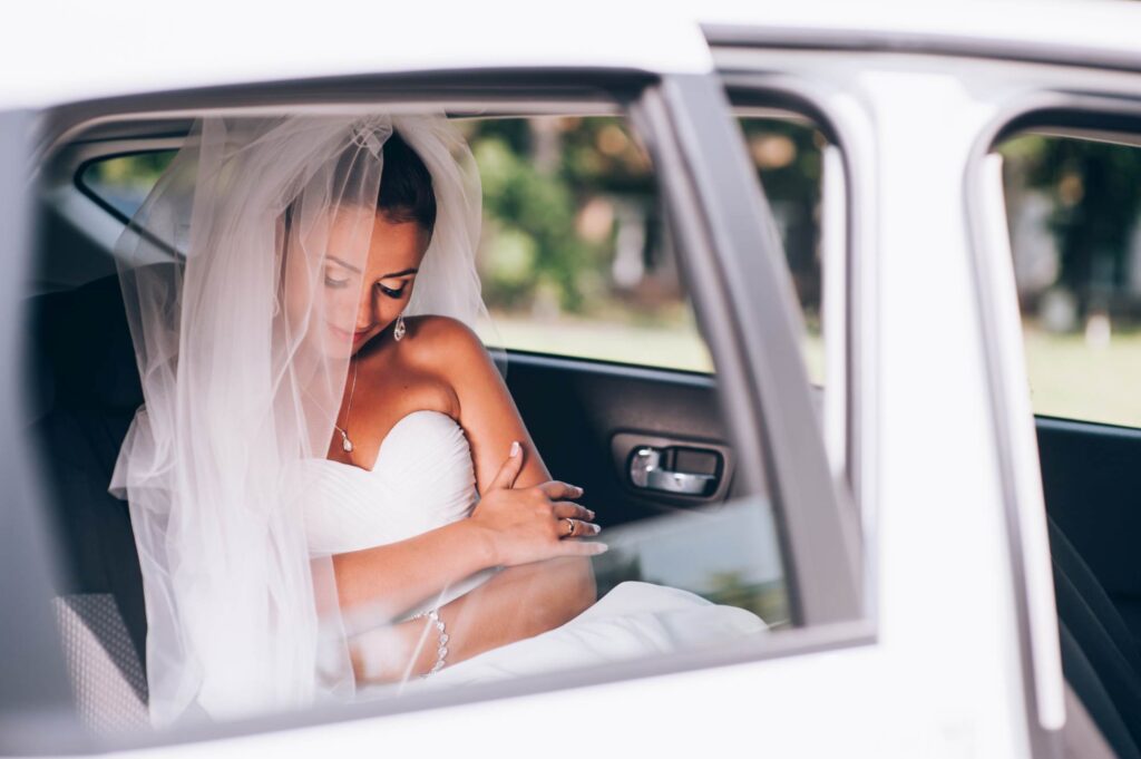 beauty bride in bridal gown with lace veil in the car. beautiful