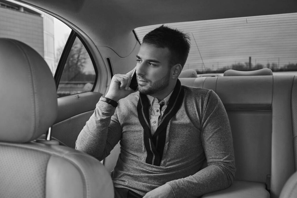 handsome businessman elegant clothing working talking phone while sitting car
